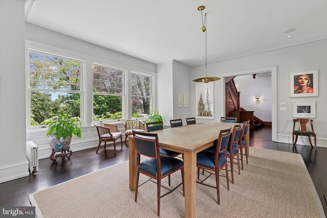 dining room featuring baseboards, dark wood finished floors, and stairway
