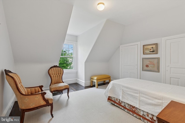 bedroom featuring baseboards, lofted ceiling, and wood finished floors