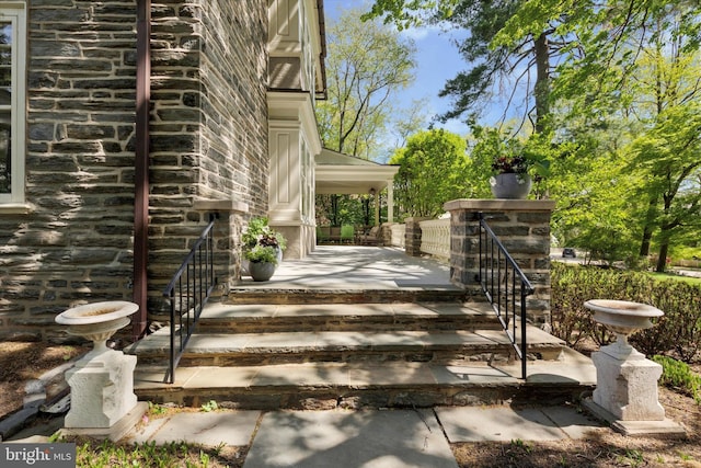 exterior space with a porch and stone siding