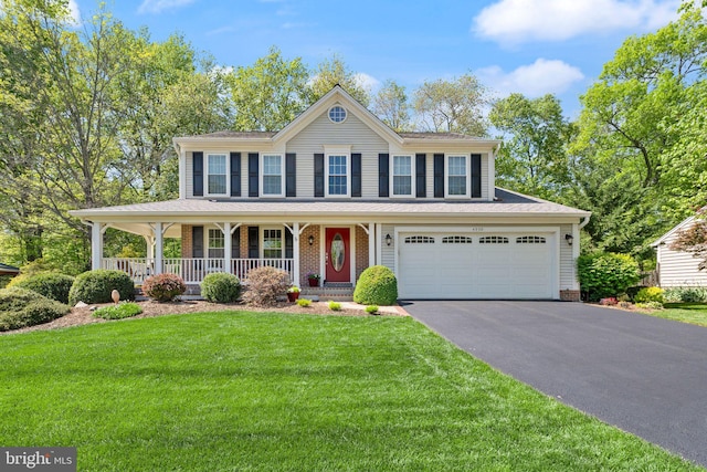 view of front of house featuring a porch, driveway, and a front yard