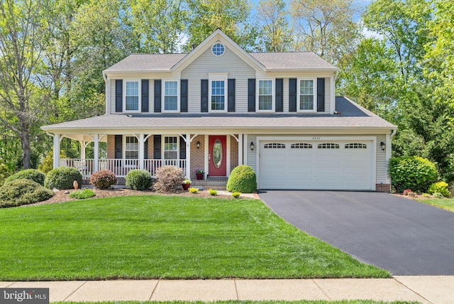 view of front of property featuring a porch, aphalt driveway, and a front yard