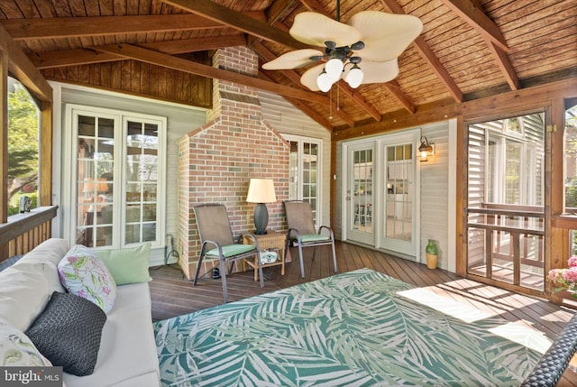 sunroom with ceiling fan and beamed ceiling