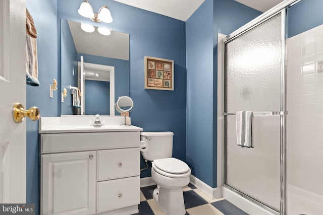 bathroom with vanity, toilet, baseboards, and a stall shower