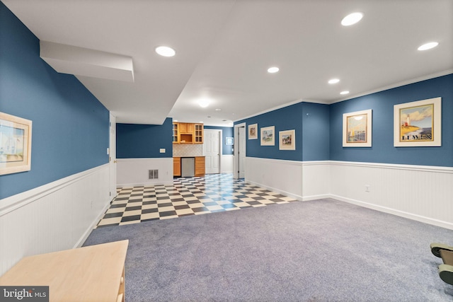 interior space with crown molding, recessed lighting, visible vents, and a wainscoted wall