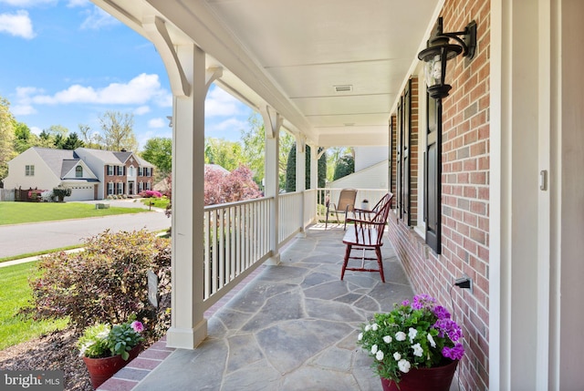 view of patio with covered porch, a residential view, and visible vents