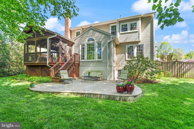 back of house featuring a lawn, fence, a patio area, and a sunroom