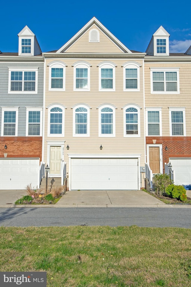 multi unit property with a garage and concrete driveway