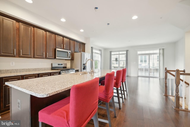 7201 Wood Pond Cir, Lanham, MD 20706 - kitchen featuring appliances with stainless steel finishes, a center island with sink, a sink, recessed lighting, and a breakfast bar area