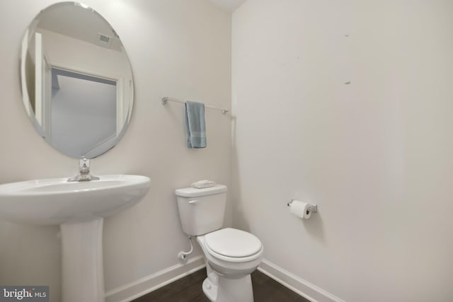 7201 Wood Pond Cir, Lanham, MD 20706 - half bath featuring baseboards, toilet, and wood finished floors