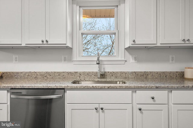 kitchen featuring a sink, white cabinets, stainless steel dishwasher, and light stone countertops