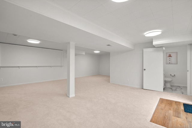 finished below grade area with carpet flooring, baseboards, and visible vents