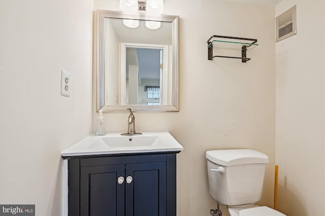 half bathroom featuring visible vents, toilet, and vanity