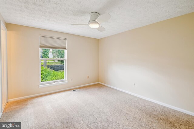 empty room with baseboards, a ceiling fan, carpet floors, and visible vents