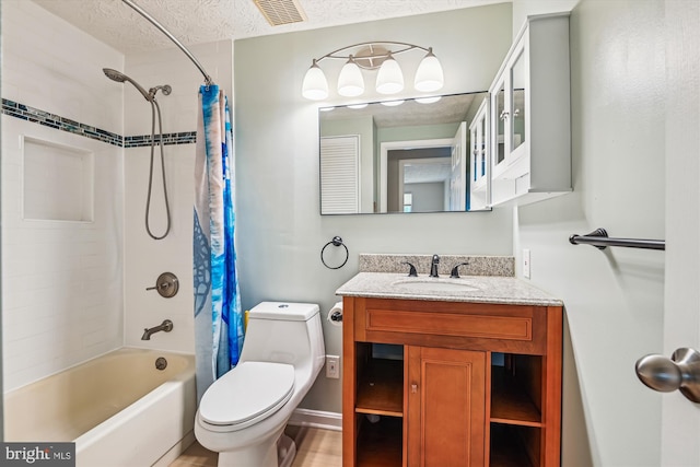 full bathroom featuring visible vents, shower / tub combo with curtain, vanity, toilet, and a textured ceiling