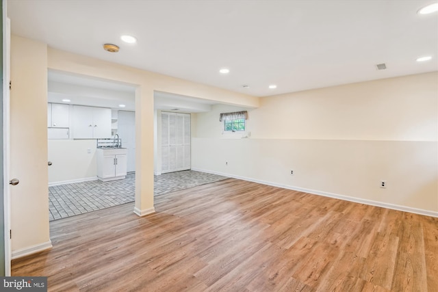 basement with recessed lighting, baseboards, visible vents, and light wood-type flooring