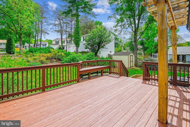 deck featuring a residential view, an outbuilding, and a shed