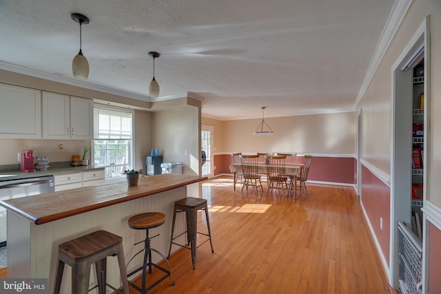 2417 Buck Hill Rd, Gerrardstown, WV 25420 - kitchen with white cabinetry, a textured ceiling, ornamental molding, and light wood-style flooring