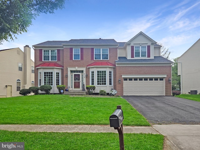 view of front of house featuring brick siding, driveway, a garage, a front lawn, and cooling unit