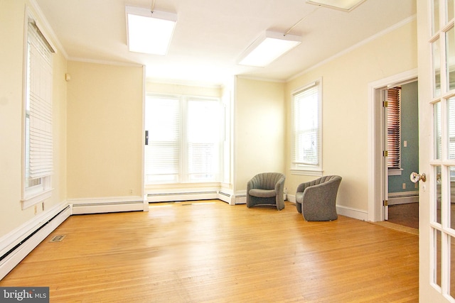 unfurnished room featuring wood finished floors, ornamental molding, and a baseboard radiator