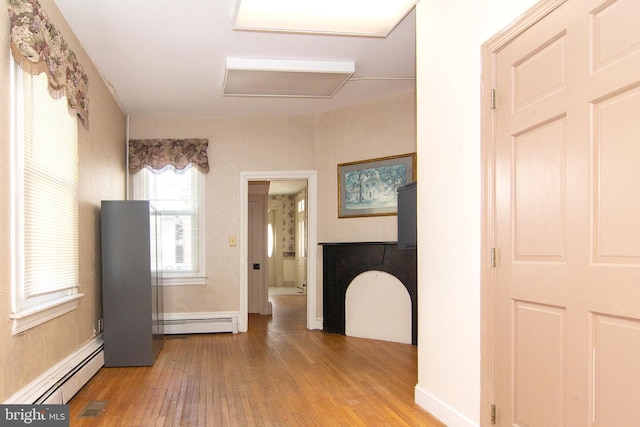 bathroom featuring baseboard heating, hardwood / wood-style floors, and visible vents