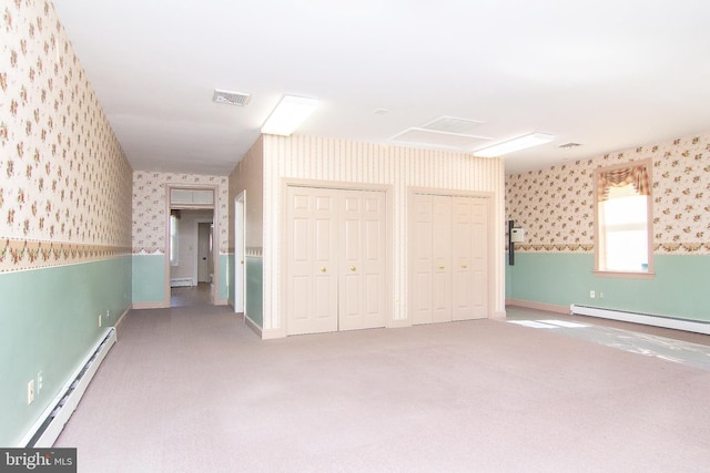 interior space featuring visible vents, multiple closets, wallpapered walls, a baseboard radiator, and carpet