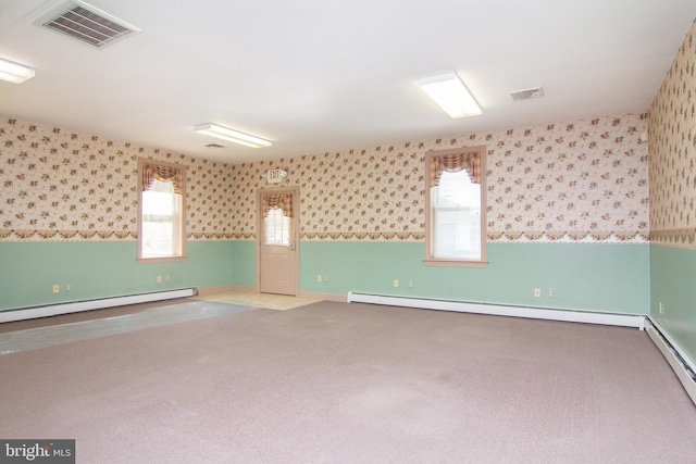 carpeted empty room featuring a baseboard heating unit, wallpapered walls, visible vents, and a baseboard radiator