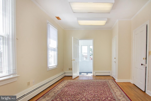 doorway with a baseboard radiator, ornamental molding, and wood finished floors