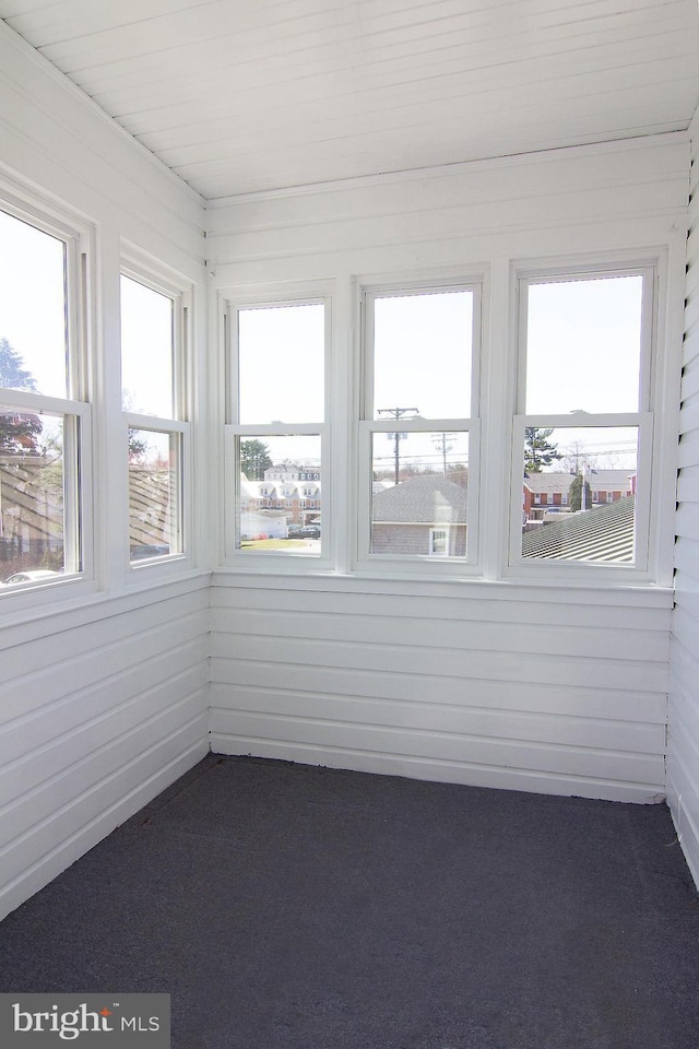unfurnished sunroom with carpet