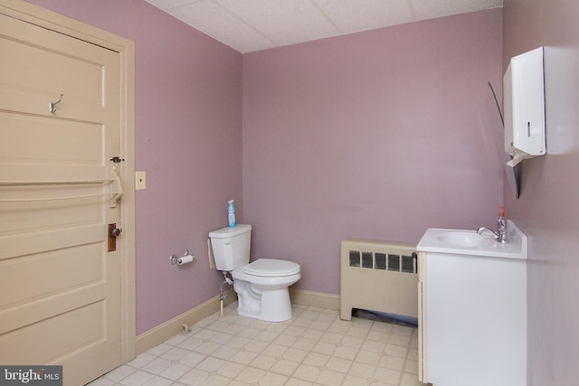 half bath featuring toilet, baseboards, radiator, and vanity