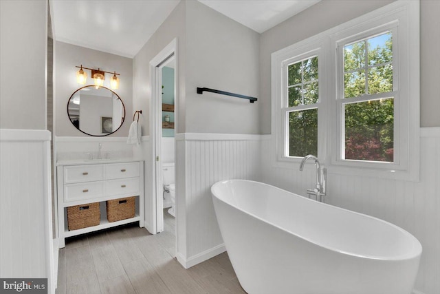 12649 Thunder Chase Dr, Reston, VA 20191 - full bathroom with a wainscoted wall, a freestanding tub, toilet, vanity, and wood finished floors