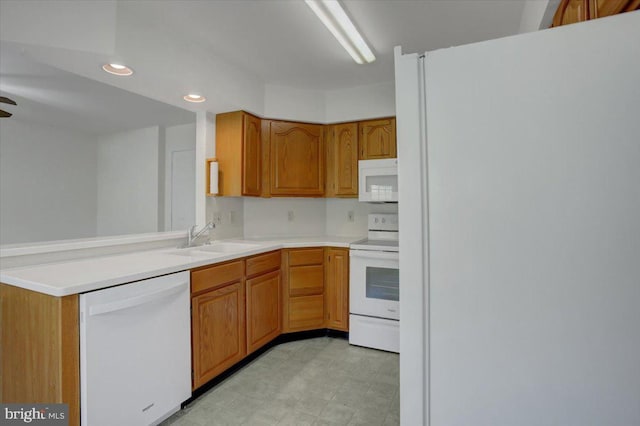 kitchen with recessed lighting, a sink, white appliances, and light countertops