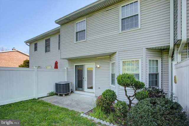 rear view of property with fence, central AC, and a patio area