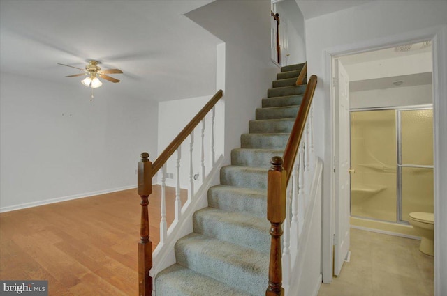 stairs with baseboards, a ceiling fan, and wood finished floors