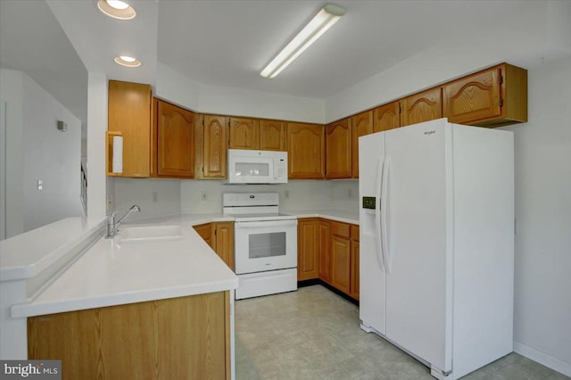 kitchen with a sink, brown cabinets, and white appliances