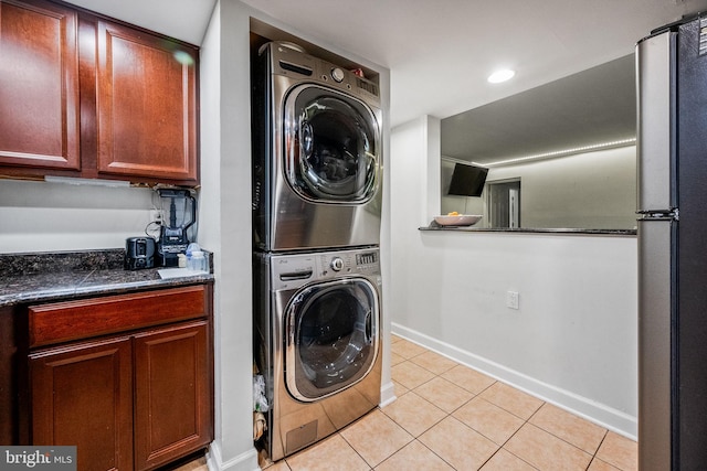 1423 Northgate Sq Unit 1423-11C, Reston, VA 20190 - laundry room featuring stacked washer / drying machine, light tile patterned flooring, and baseboards