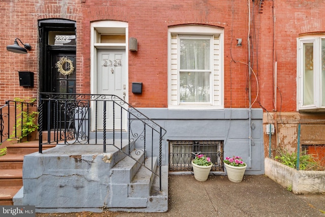 view of exterior entry featuring brick siding