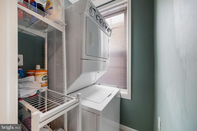 clothes washing area featuring laundry area and stacked washer / dryer