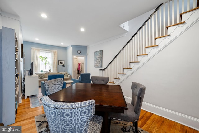 dining space with light wood-type flooring, recessed lighting, baseboards, and stairway