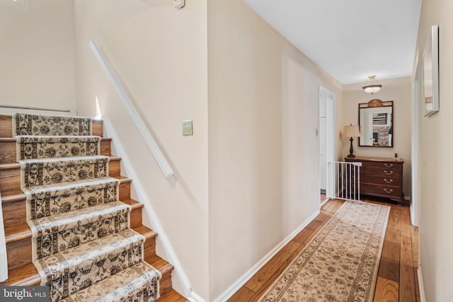 stairway with baseboards and hardwood / wood-style floors