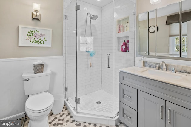 full bathroom featuring vanity, a stall shower, and toilet