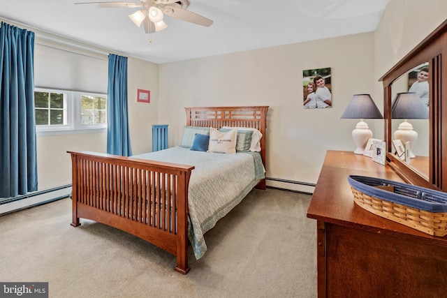 carpeted bedroom featuring a ceiling fan and a baseboard heating unit