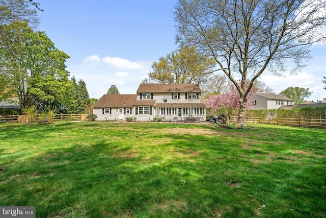 back of property with a lawn, a chimney, and a fenced backyard
