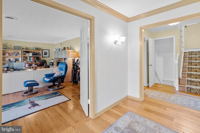 hallway featuring stairway, ornamental molding, and hardwood / wood-style floors