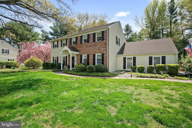 colonial house with brick siding and a front lawn