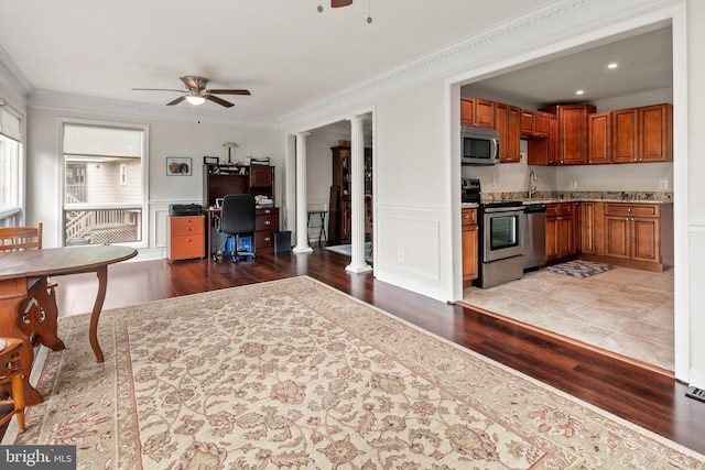 kitchen featuring brown cabinets, a ceiling fan, appliances with stainless steel finishes, and wood finished floors