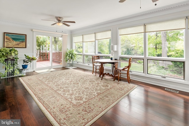 sunroom with crown molding, wood finished floors, and visible vents