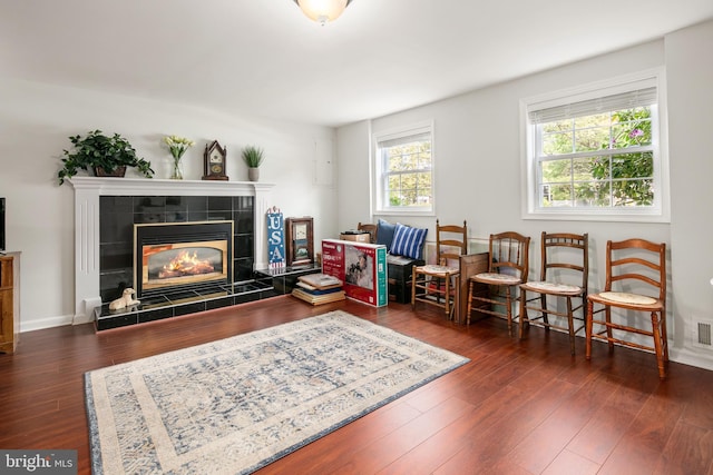 living area with a fireplace, wood finished floors, and visible vents