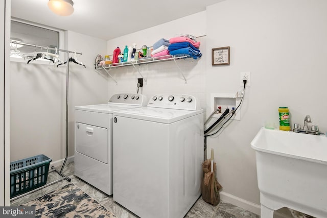 washroom featuring laundry area, a sink, baseboards, and independent washer and dryer