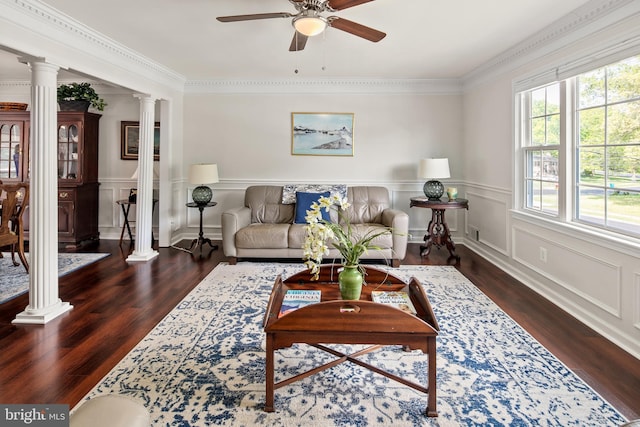 living area with ornate columns, a ceiling fan, a decorative wall, and wood finished floors