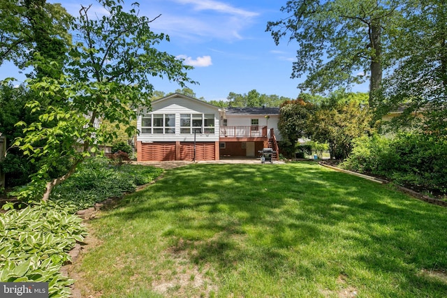 back of house with a lawn, a wooden deck, a sunroom, and stairway